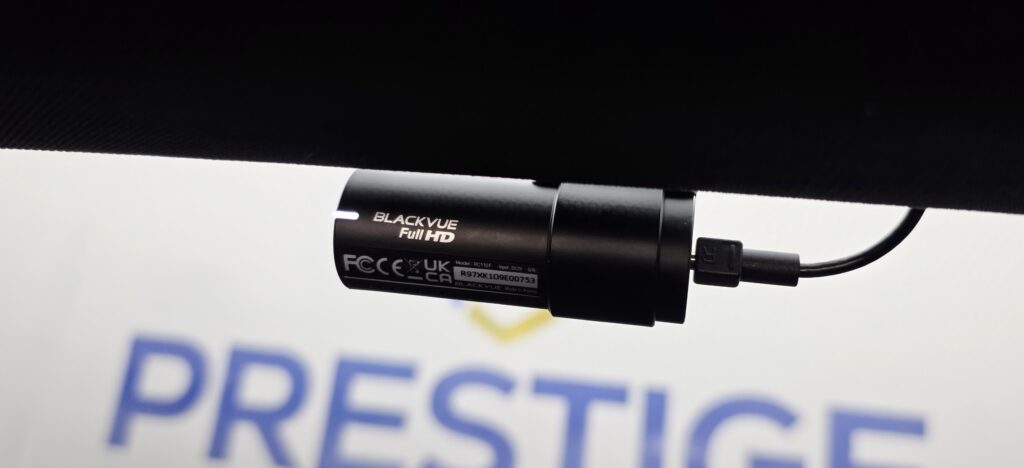 BlackVue dash cam unit resting in front of the Prestige Protection logo